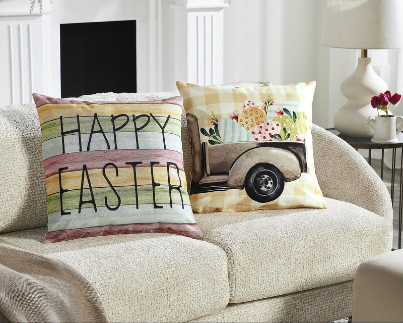 Two decorative pillow covers with 'Happy Easter' text and Easter egg designs on them, displayed on a neutral couch.